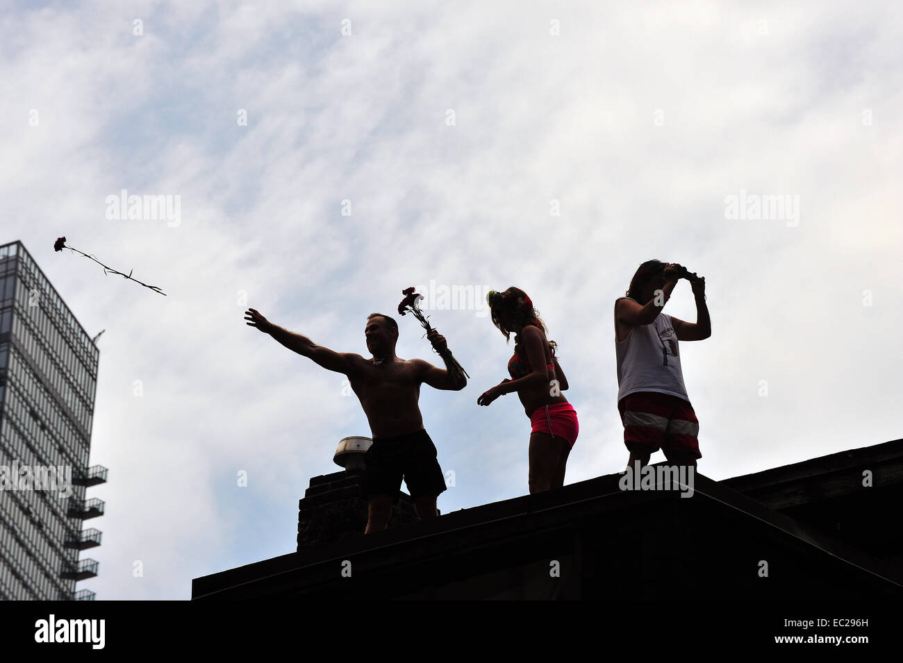 La silhouette di persone su un tetto di gettare fiori al 2014 World Pride a Toronto. Foto Stock