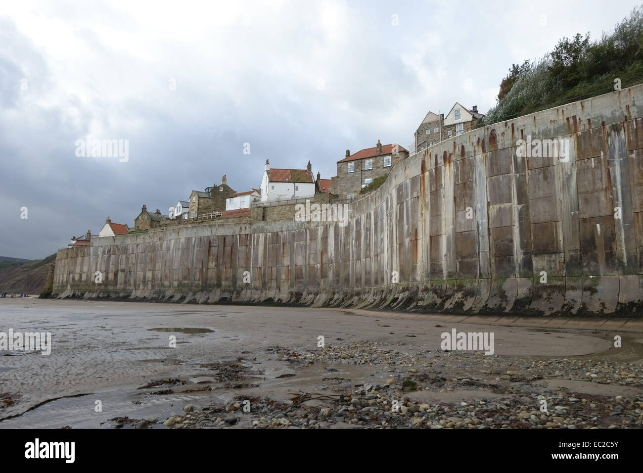 Alto mare concrete difese a Robin Hood's Bay, un piccolo villaggio di pescatori costieri e bay con un Jurassic cliff costa sul Foto Stock