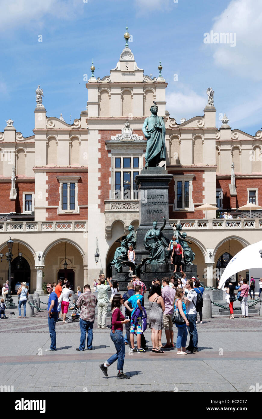 I turisti di fronte al monumento Mickiewicz sulla piazza del Mercato di Cracovia in Polonia. Foto Stock