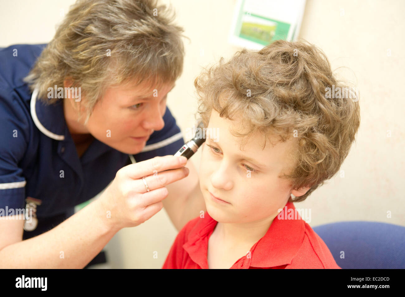Un giovane ragazzo ha i suoi orecchi esaminati da un infermiere Foto Stock