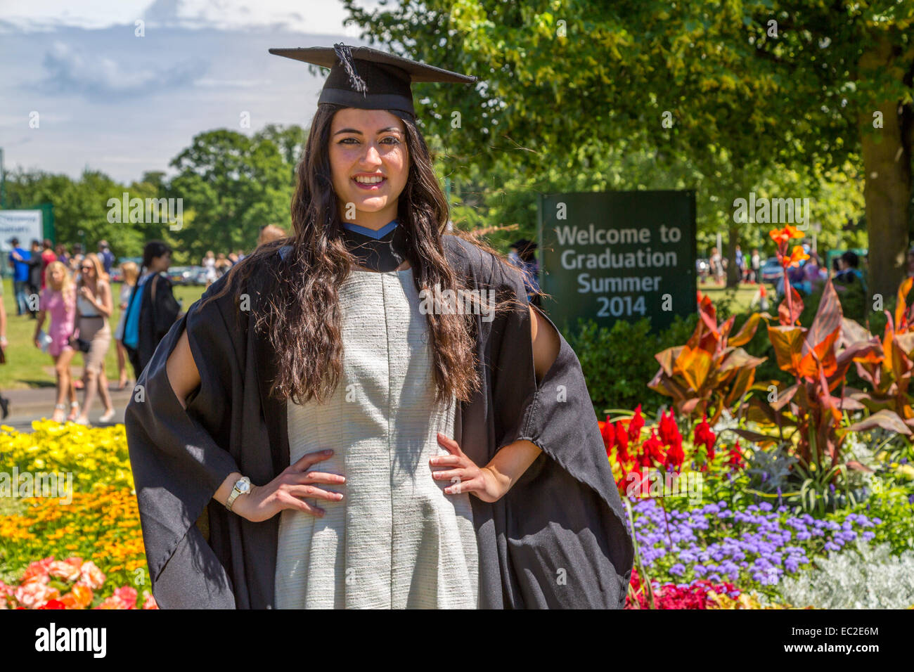 Una femmina di studente universitario in posa la sua laurea cappello e camice Foto Stock