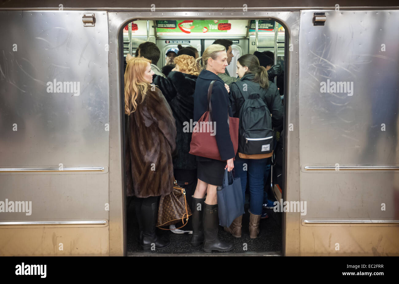 Folla di passeggeri in un treno della metropolitana con i loro zaini e borse di New York il giovedì, 26 novembre 2014. (© Richard B. Levine) Foto Stock