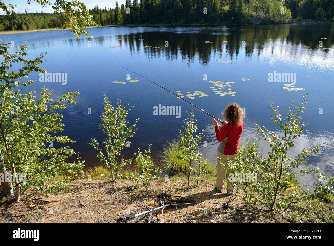 Donna pescatore sul lago vicino a Strömsund, Jämtland, Svezia Foto Stock