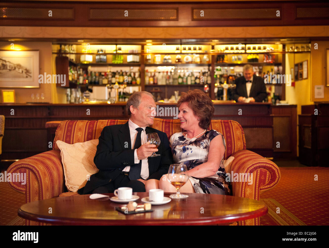 Una coppia di anziani con un drink insieme nel bar di un hotel in Inghilterra Foto Stock