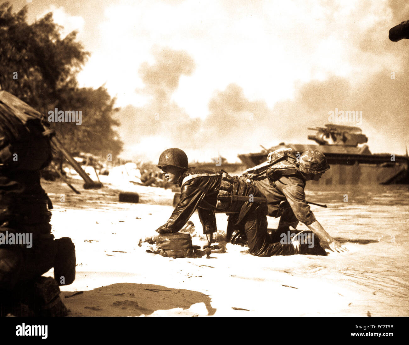 Sembra che un marine è alleviare un altro sulla spiaggia di Saipan ma sono davvero di strisciare sotto il fuoco nemico, alle loro posizioni assegnate. giugno 1944. sgt. James ustioni. (Marine Corps) Foto Stock