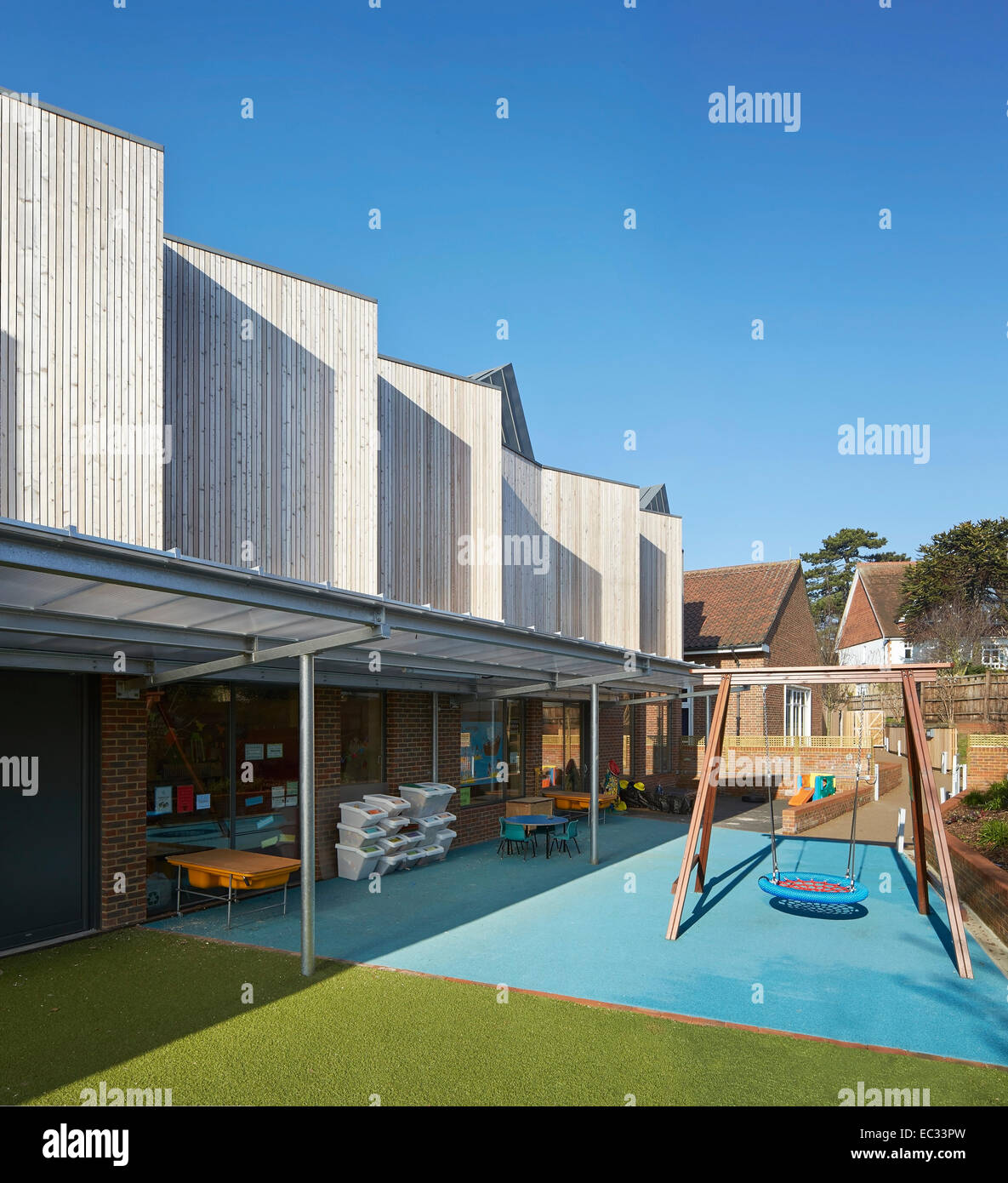 Hollymount School di Londra, Regno Unito. Architetto: Haverstock Associates LLP, 2013. Prospettiva di facciata con parco giochi e co Foto Stock