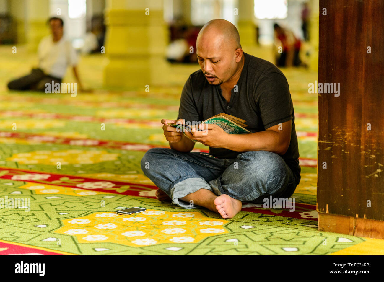 Uomo che prega in corrispondenza di una delle moschee di Singapore. Foto Stock