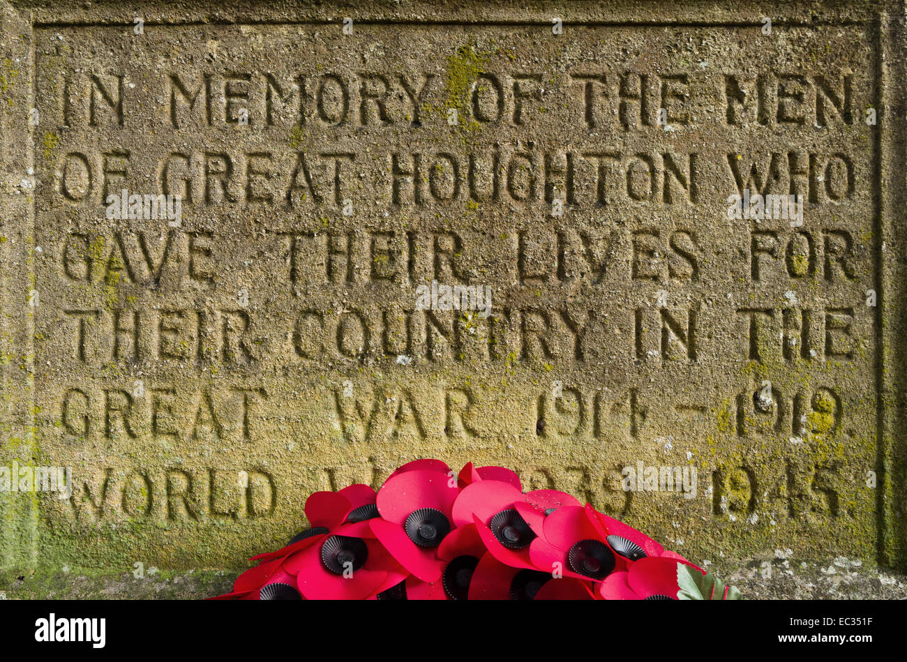 Iscrizione scolpita in pietra sul grande villaggio di Houghton War Memorial, una corona di papaveri alla base. Foto Stock