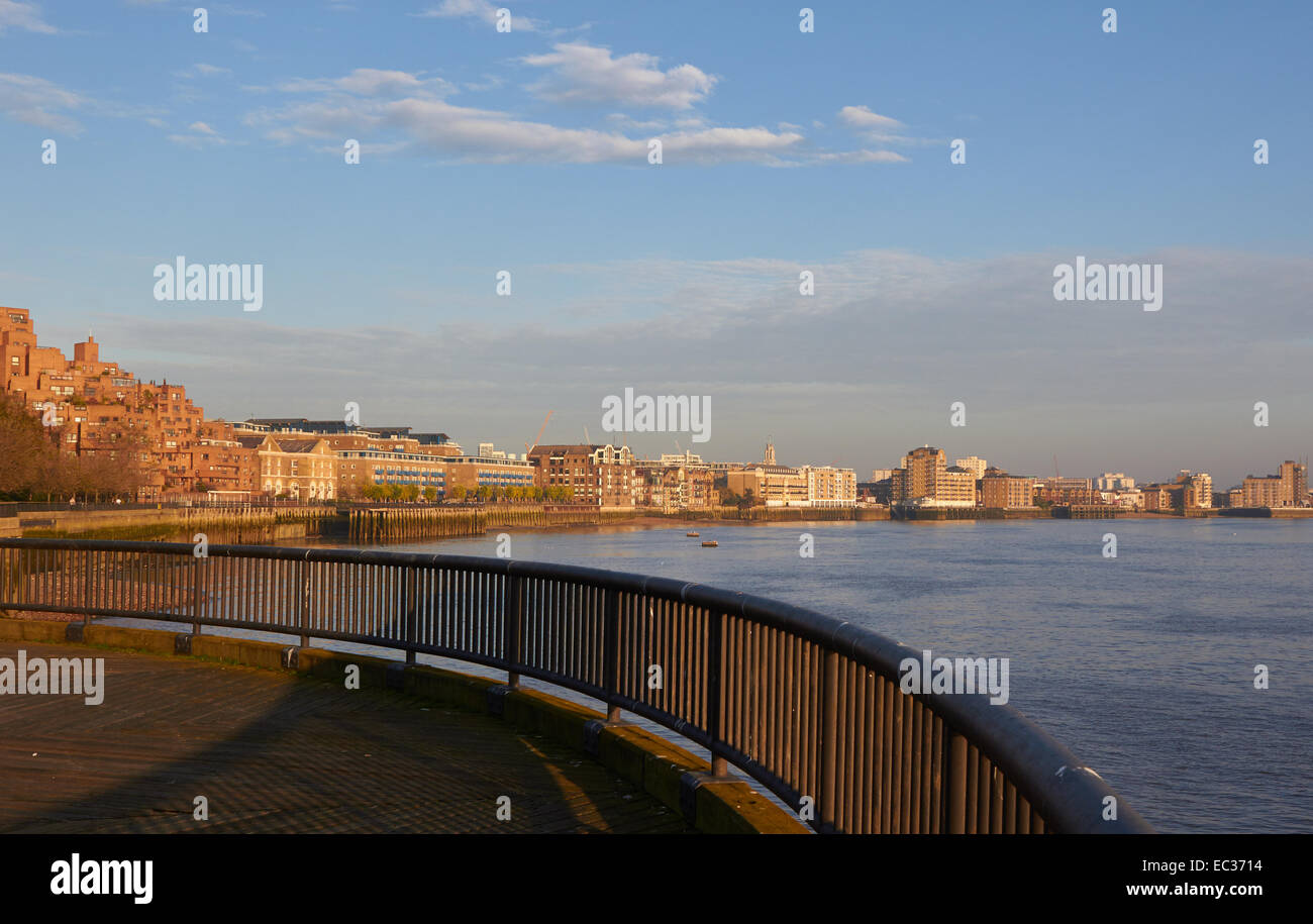 Alcuni appartamenti moderni e altri in ex magazzini linea un ansa del Tamigi a crepuscolo est Londra Inghilterra Europa Foto Stock