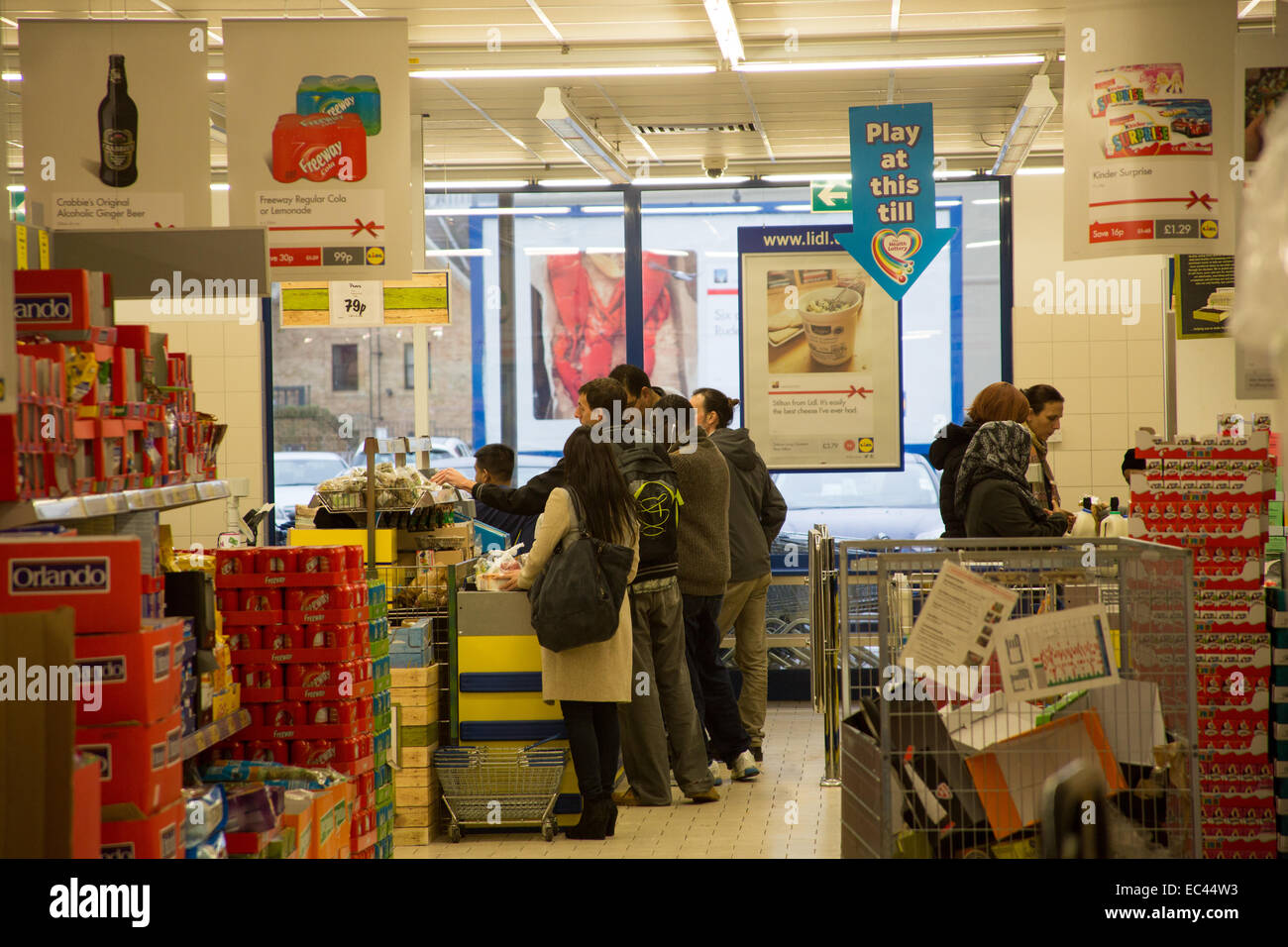 Gli acquirenti di Lidl queing presso una cassa fino a pagare Foto Stock