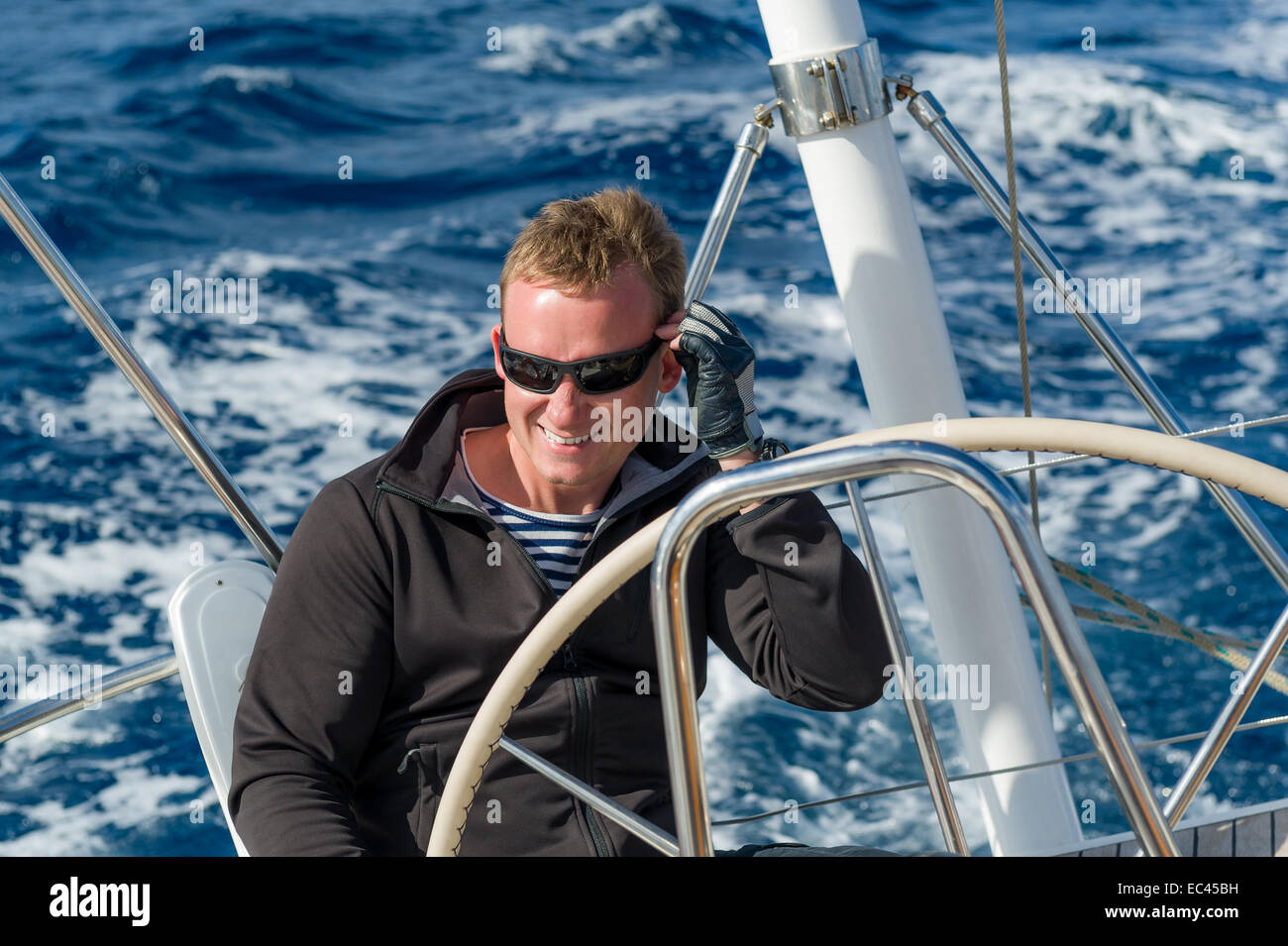 Allegro skipper sul timone della barca a vela Foto Stock