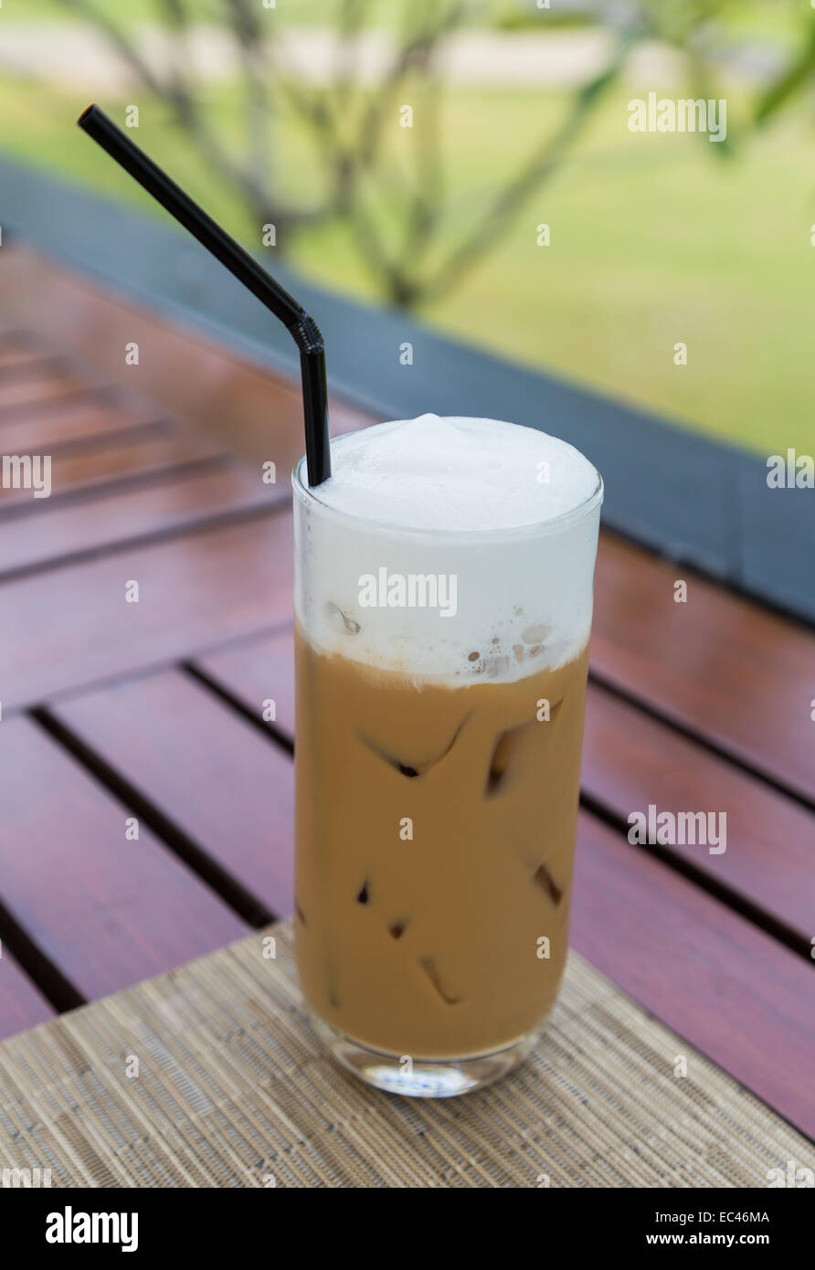 Caffè ghiacciato in un bicchiere con del latte con la schiuma. Foto Stock