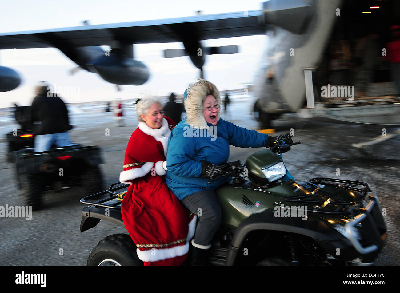 La sig.ra Santa Claus corse off su un ATV durante una visita in un remoto villaggio inuit come parte di Operazione Babbo Natale 16 dicembre 2009 in Gambell, Alaska. Operazione Babbo Natale ha consegnato donati doni ai poveri remoti villaggi in Alaska dalla Air Force trasporti dal 1951. Foto Stock