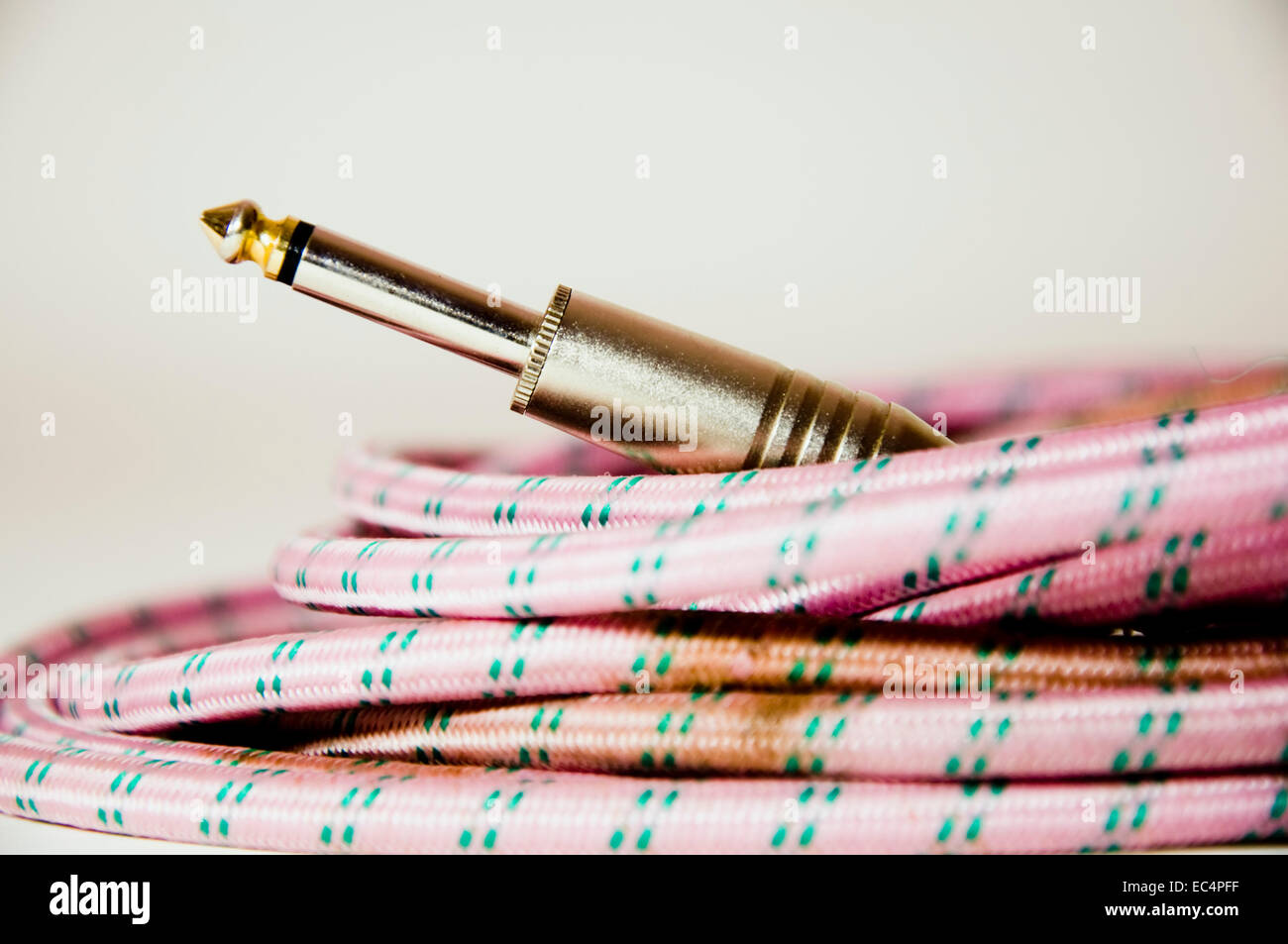 Primo piano di una rosa retrò cavo chitarra Foto Stock