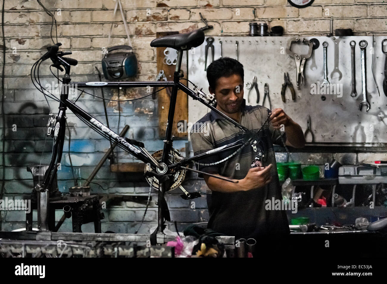 Una bicicletta meccanico assembla un custom made bike in scala piccola fabbrica di biciclette a Bogotà, Colombia, 10 aprile 2013. A causa della forte e vibrante cultura del ciclismo in Colombia, con escursioni in bicicletta essendo uno dei due sport più popolari nel paese, decine di bike workshop e artigianale, spesso a conduzione familiare bicicletta fabbriche sono sempre state sparse fuori attraverso la città colombiana. Tuttavia, le crescenti importazioni a basso prezzo di biciclette e componenti dalla Cina nel corso degli ultimi dieci anni ha portato ad un calo significativo nel mercato nazionale di produzione di biciclette. Tradizionale nessun nome di costruttori di moto sono costrette a chiudere le loro fac Foto Stock