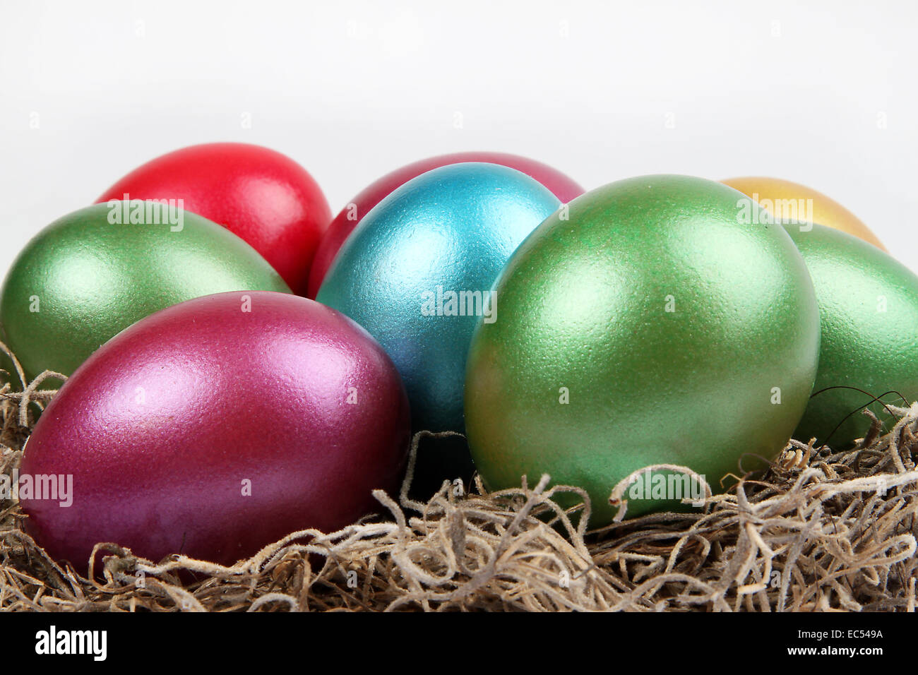 Vivacemente colorati metallici le uova di Pasqua in erba naturale Foto Stock