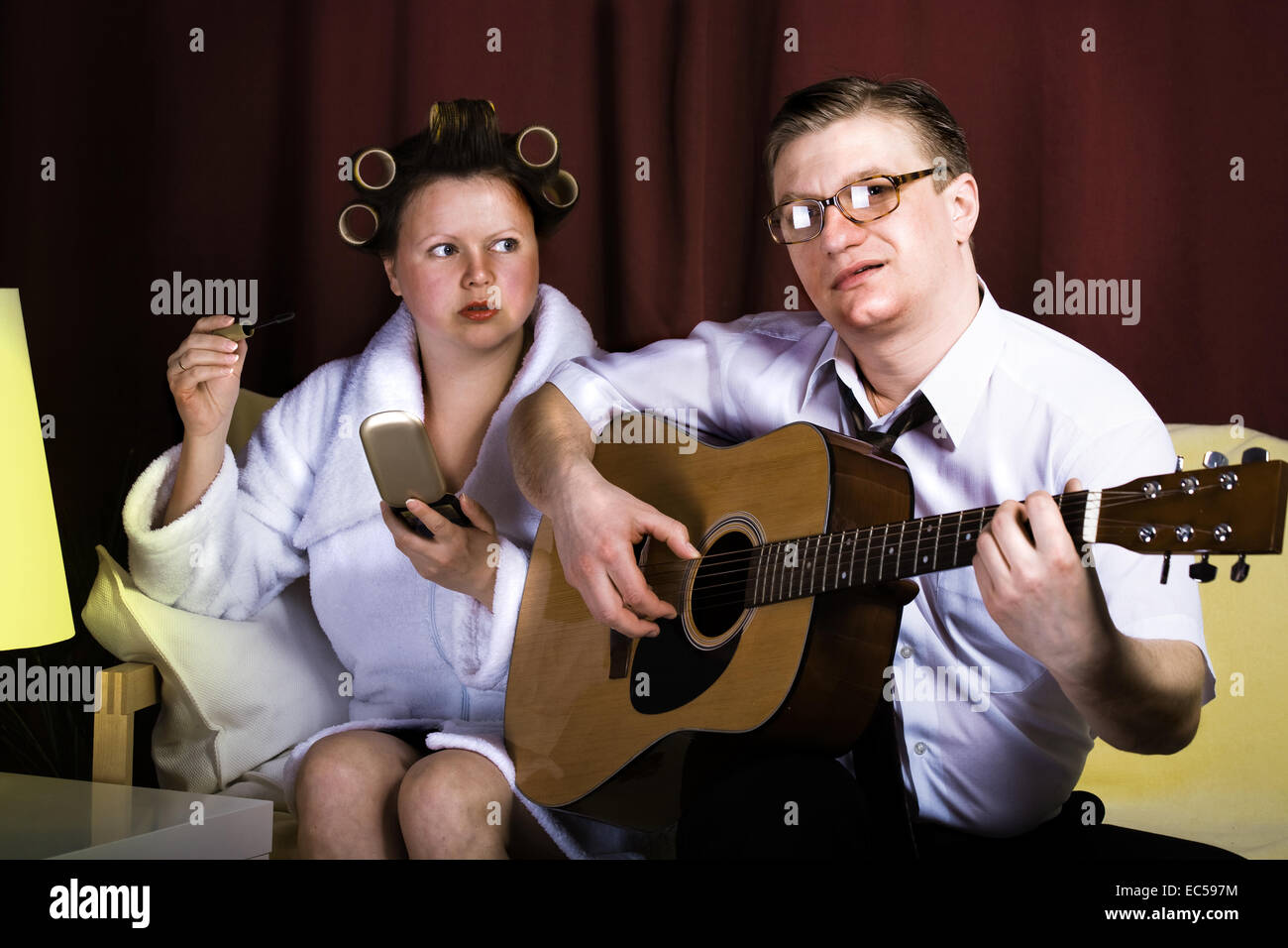 Crazy Family series un uomo suonare la chitarra per sua moglie Foto Stock
