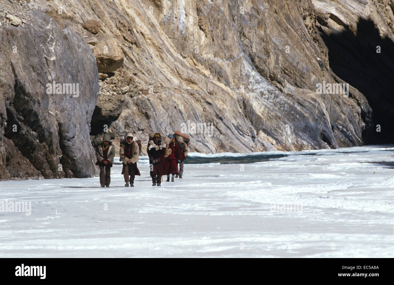 Ladakh sul fiume di ghiaccio. Una spedizione attraversa il ghiaccio. Regione montagnosa. Le figure a piedi in una linea. Foto Stock