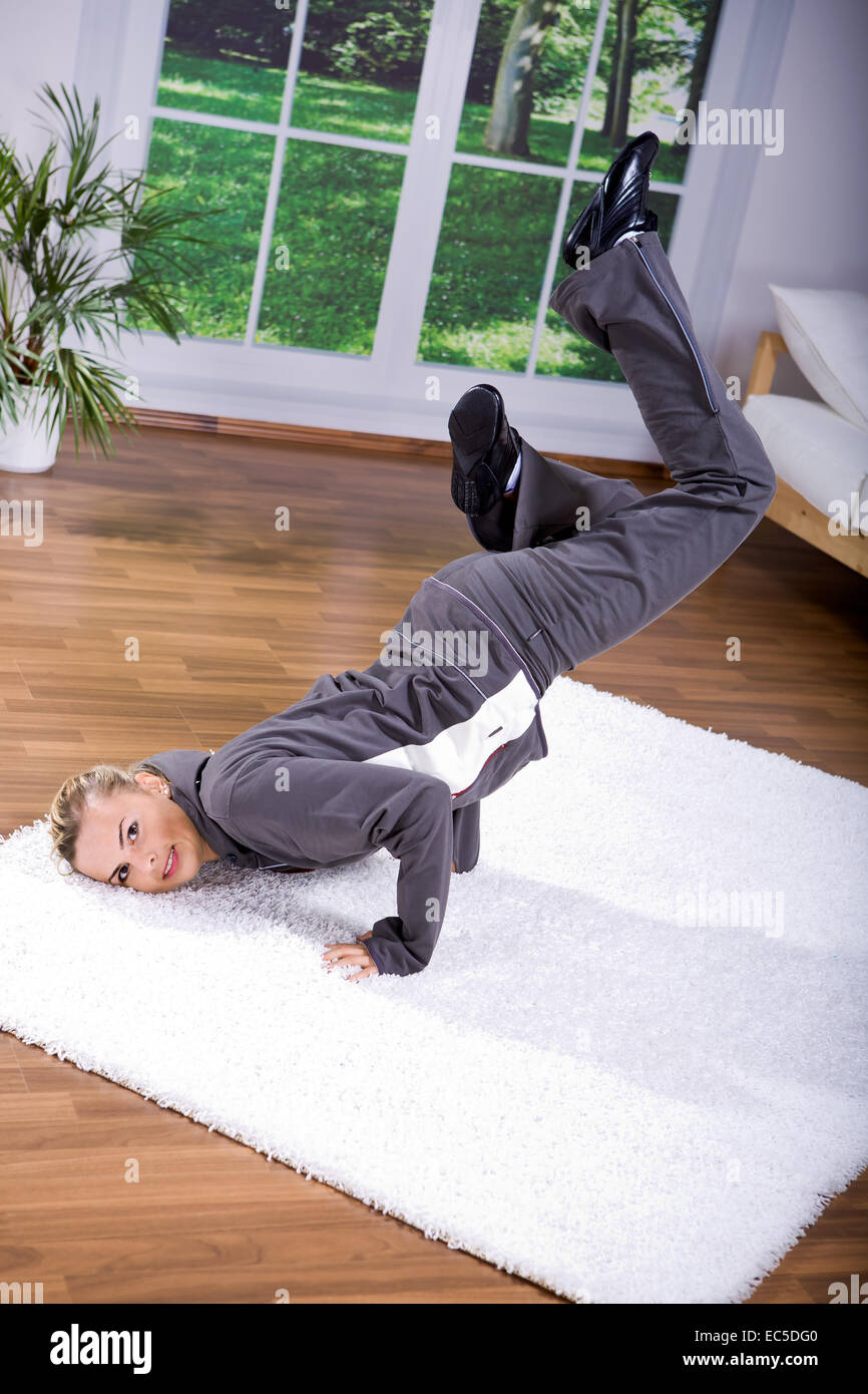 Giovane donna fare esercizi yoga a casa Foto Stock