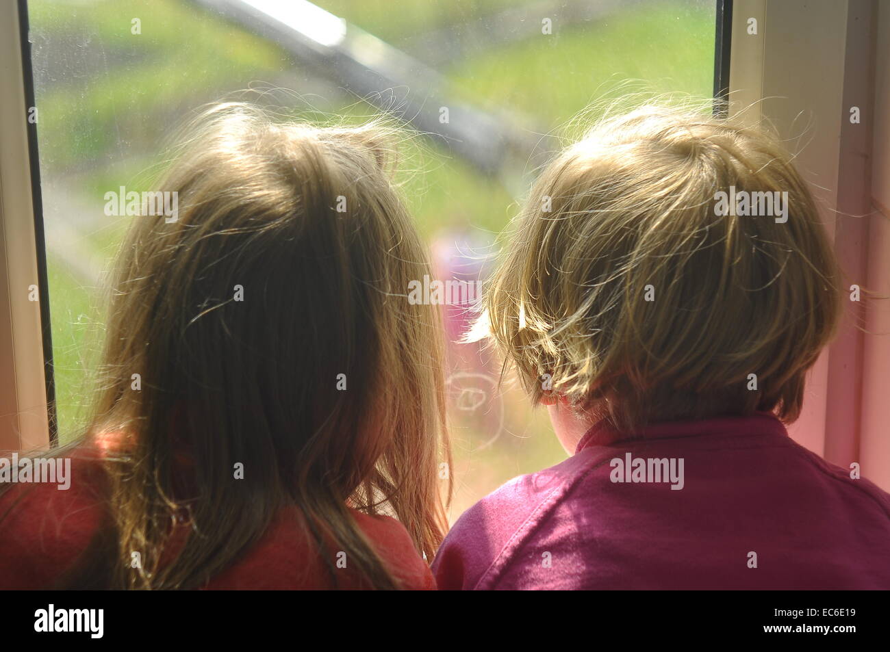 Kinder am Fenster Foto Stock