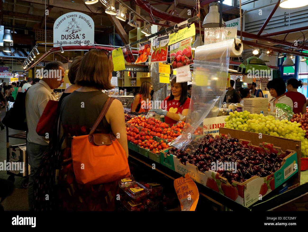 Donna asiatica fornitore di frutta che serve i clienti al Granville Island il Mercato Pubblico, Vancouver, British Columbia, Canada Foto Stock