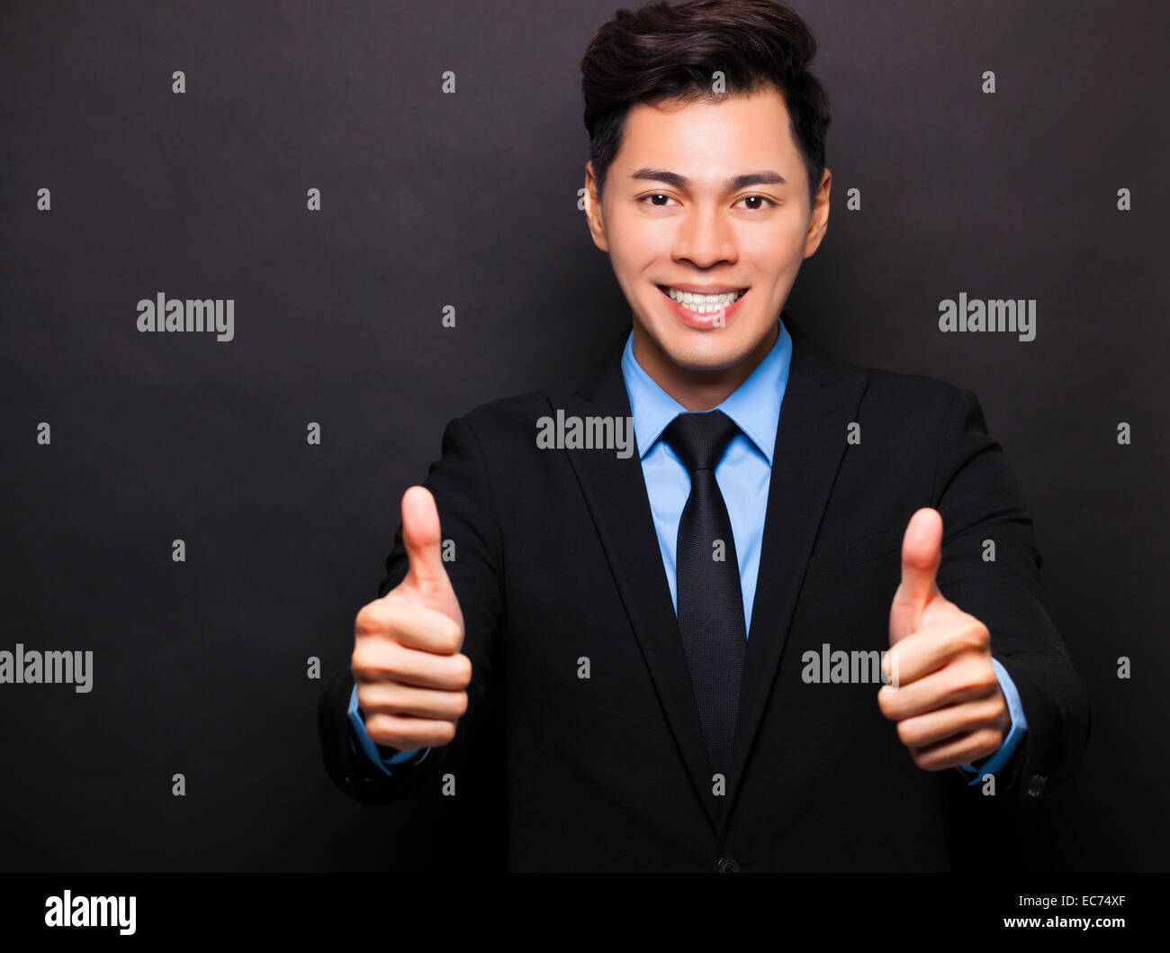 Sorridente imprenditore asiatico con il pollice in alto Foto Stock