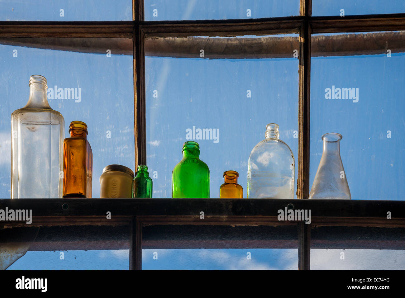 Vecchie bottiglie di vetro nella finestra Foto Stock