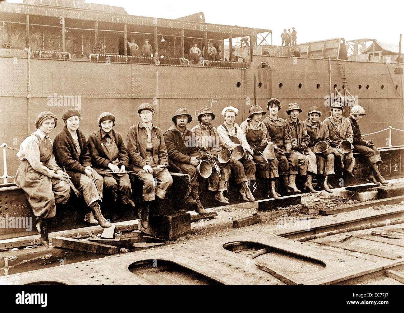 Il rivetto di donne i riscaldatori e i passanti a prendere una pausa dalla nave da guerra i lavori di costruzione. Navy Yard, Puget Sound, Washington. Il 29 maggio 1919. Foto Stock Il rivetto di donne i riscaldatori e i passanti a prendere una pausa dalla nave da guerra i lavori di costruzione. Navy Yard, Puget Sound, Washington. Il 29 maggio 1919. Foto Stock
