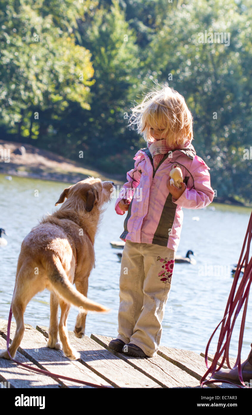 Bambina e mendicando cane su una passerella Foto Stock