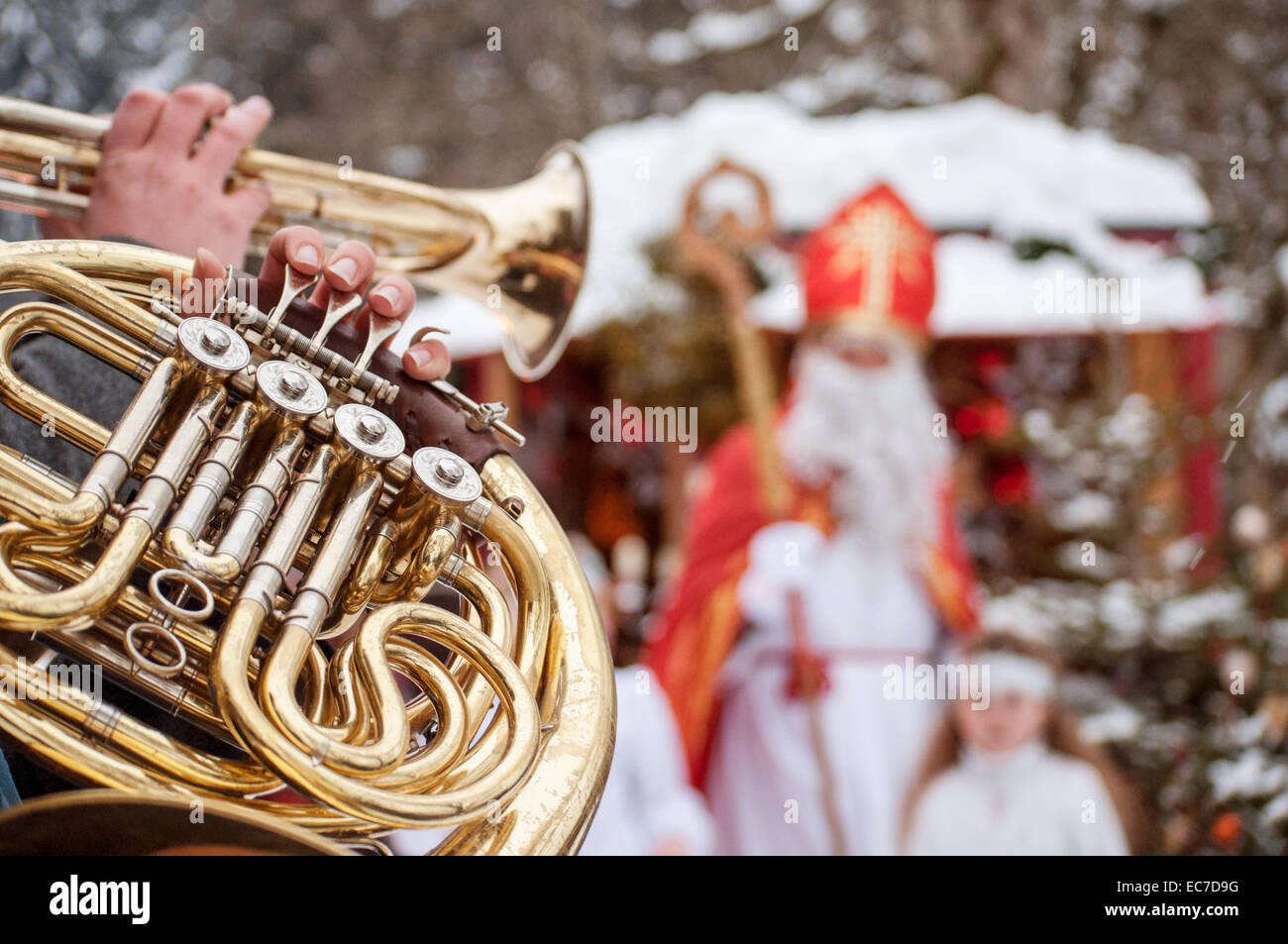 Musicista suonare il clacson con angelo e Santa Claus in background Foto Stock