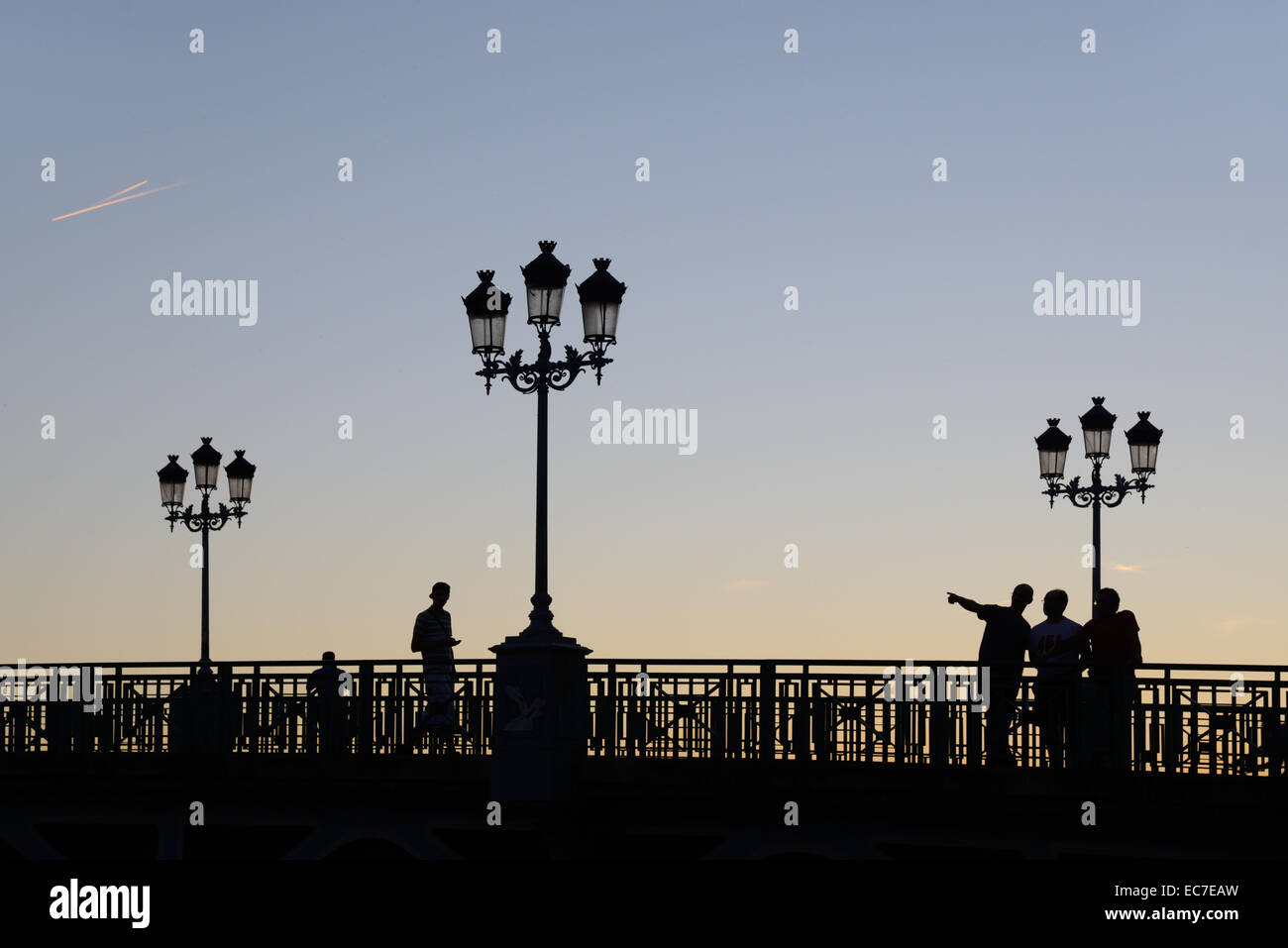 Sera sagome delle lampade stradali & Persone sul Pont St Pierre ponte sopra il fiume Garonne Toulouse Haute Garonne Francia Foto Stock
