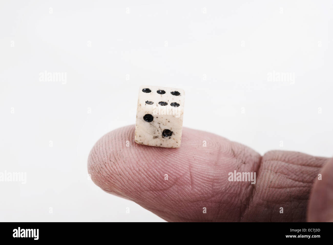 Un vecchio osso vittoriano bilanciamento dei dadi sul dito indice pronto per essere gettati e la sorte dei passi della filiera trovato lato superiore 6 Foto Stock