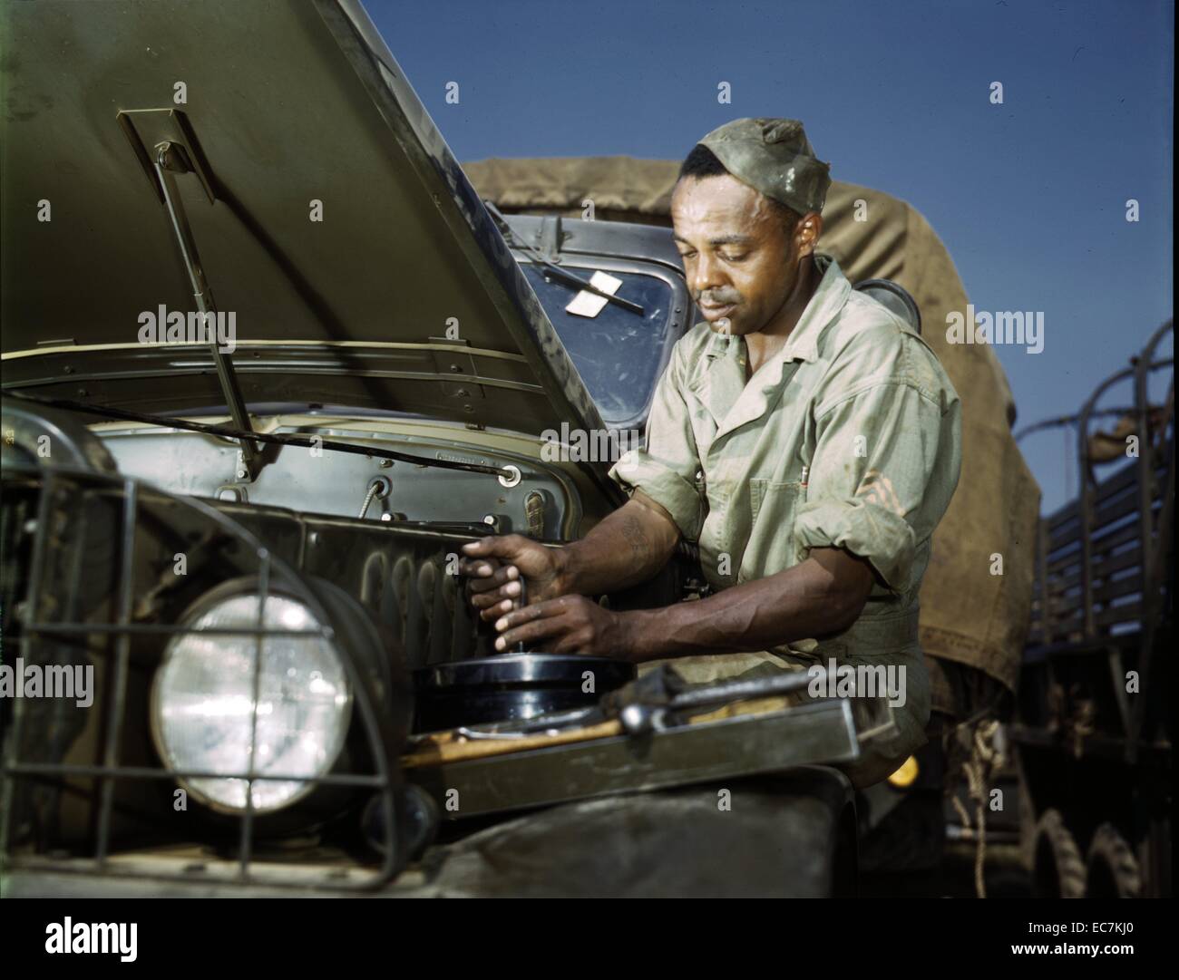 Un colorato lavoro meccanico nell'US Army motore della sezione manutenzione a Fort. Knox, Ky, 1942. Foto Stock