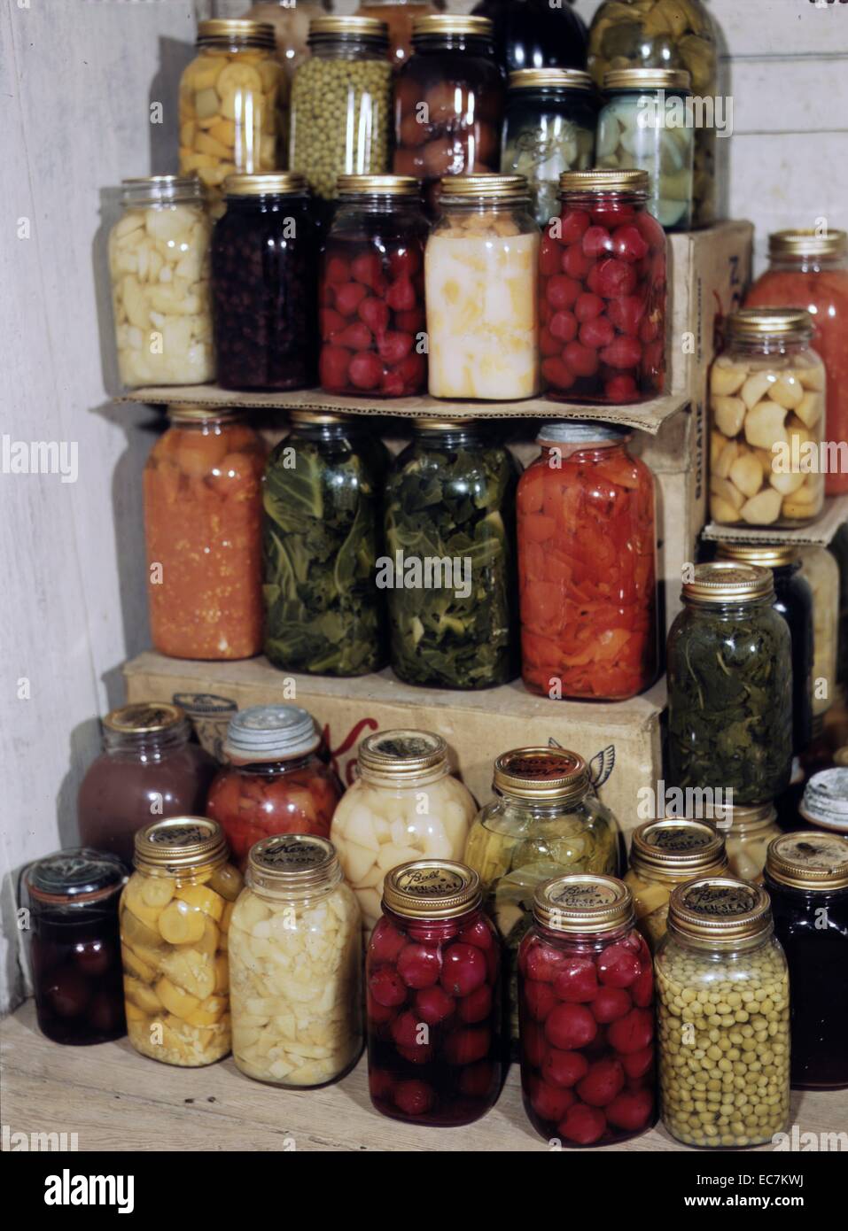 Visualizzazione della home-conserve alimentari mostra fotografica di vasetti di zucca gialla, piselli, barbabietole, e altri ortaggi. Foto Stock