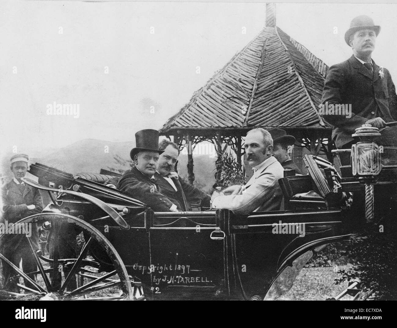 Presidente McKinley in Asheville. Presidente McKinley e altri in posa di un automobile aperta con le montagne e la struttura rustica in background. McKinley (1843-1901)era il venticinquesimo Presidente degli Stati Uniti e ha portato la nazione alla vittoria in spagnolo-guerra americana, sollevato tariffe protezionistiche per promuovere l'industria americana, e mantenuta la nazione il gold standard in un rigetto delle proposte inflazionistiche. Foto Stock