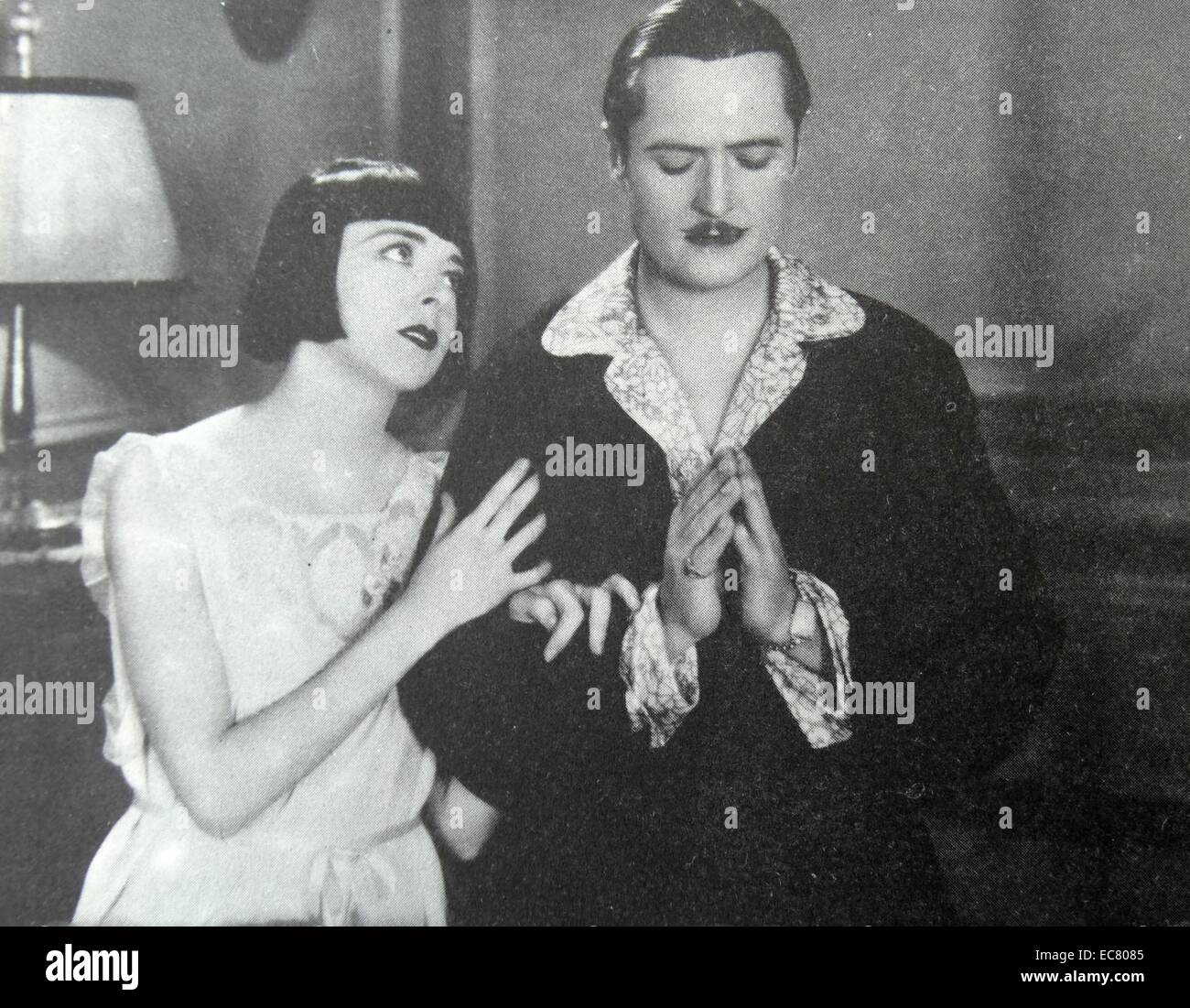 La felicità di fronte, 1928. La potenza di una buona donna. Colleen Moore insegna i gangster Edmund Lowe a pregare sulla loro notte di nozze. Foto Stock