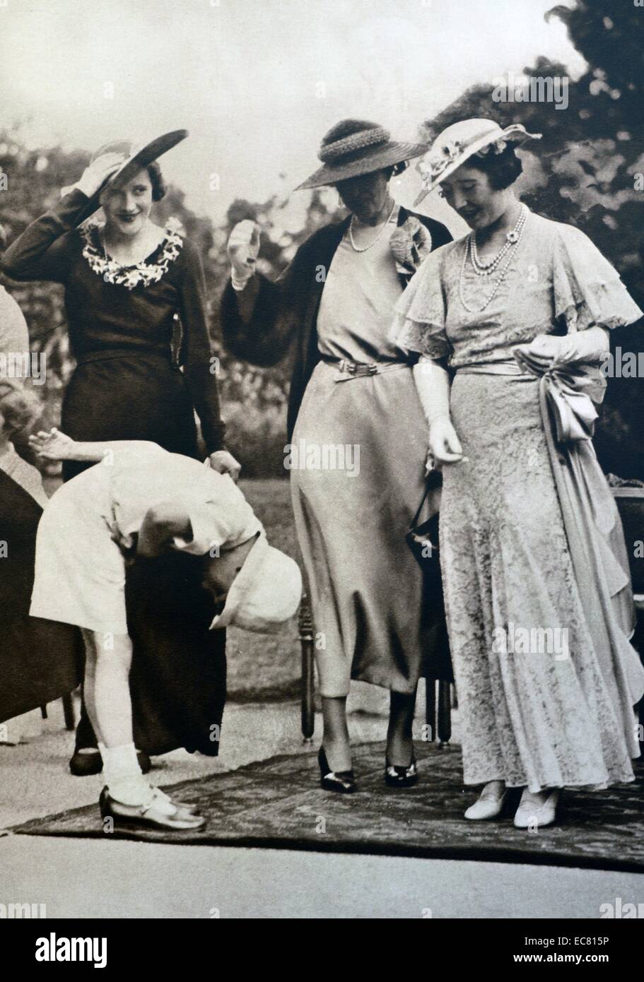 Il Duca e la Duchessa per partecipare ad una festa in giardino che si è tenuto presso il St James's Palace, in aiuto del benessere dell'Infanzia. Un giovane bambino archi alla duchessa, assicurando che la postura corretta è usata. Prese nel 1935, poco dopo il suo rientro da Bruxelles. Foto Stock