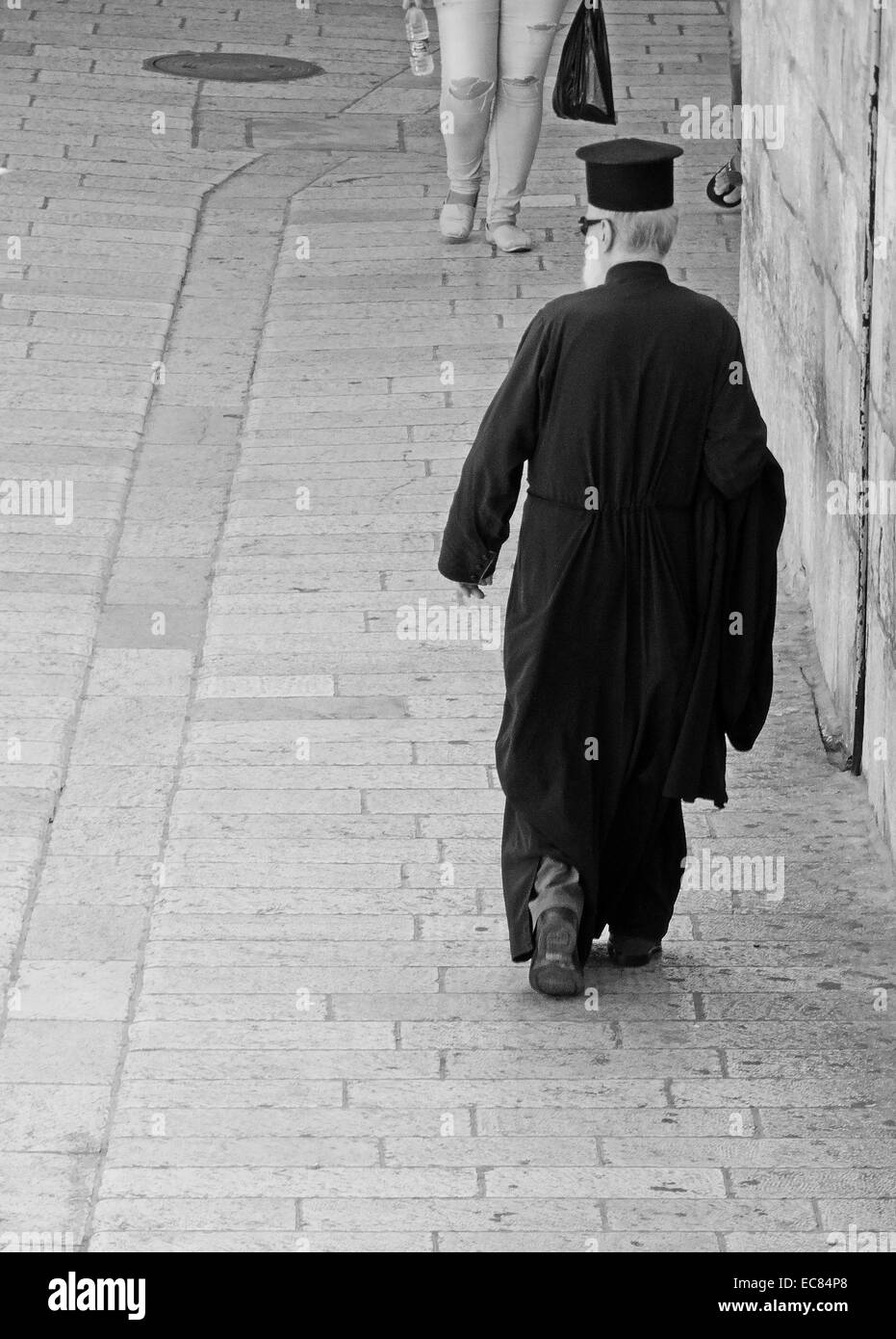 Greco-ortodossi sacerdote passeggiate attraverso la città vecchia di Gerusalemme Est; Israele. Foto Stock