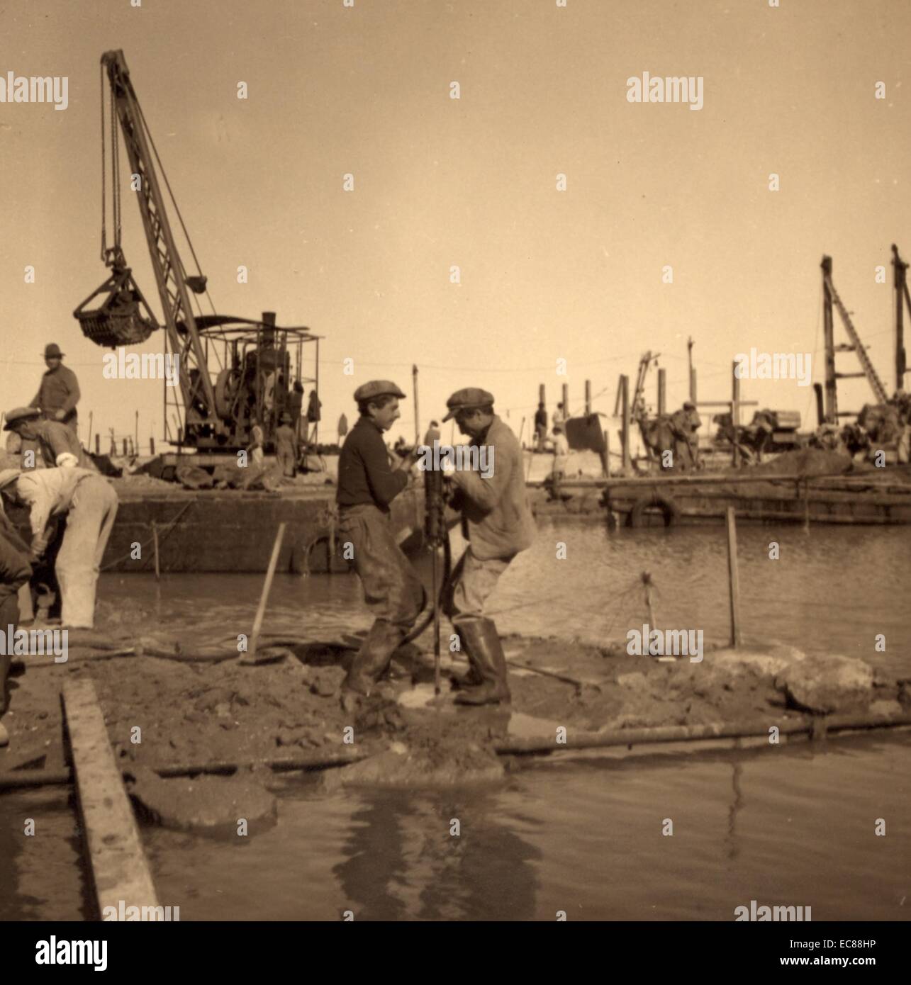 Fotografia dei lavoratori la costruzione di una barca utilizzando per impieghi pesanti trapani elettrici. Tel Aviv, Palestina, Israele. Datata 1925 Foto Stock