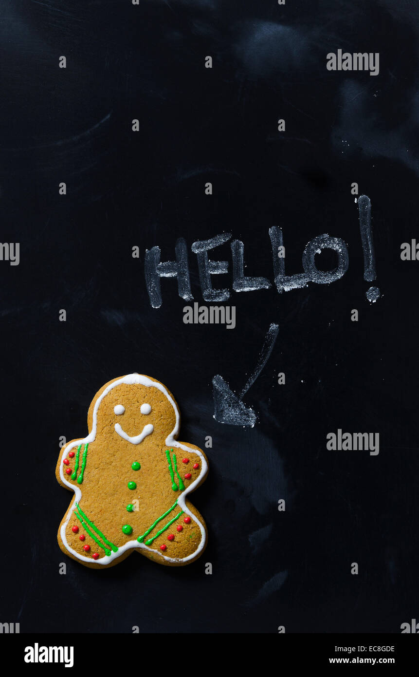 Il Gingerbread Man dire "ciao" sulla lavagna nera, sopra visualizza Foto Stock