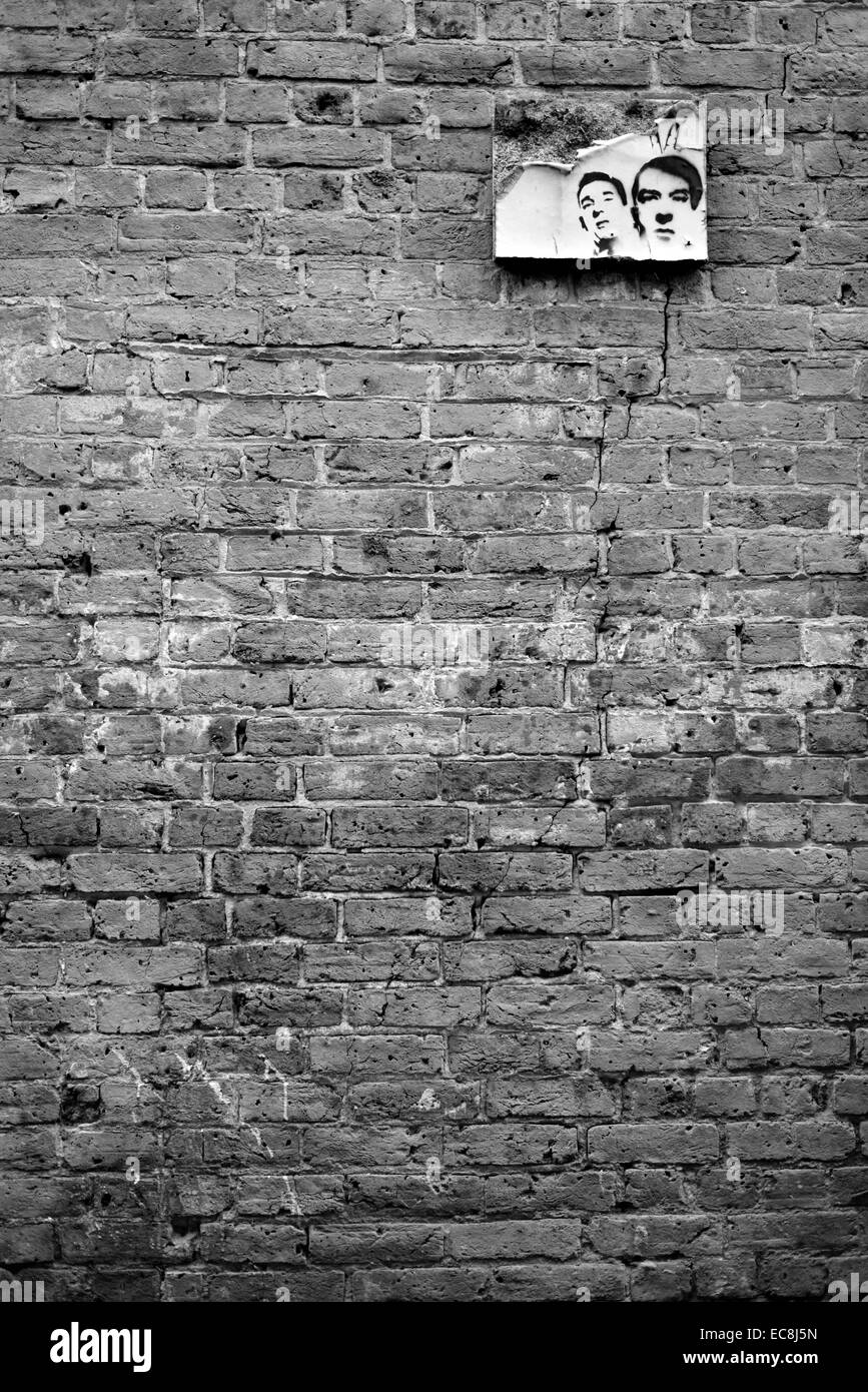 Parete con peeling arte dei graffiti poster del Krays. Monocromatico. Foto Stock