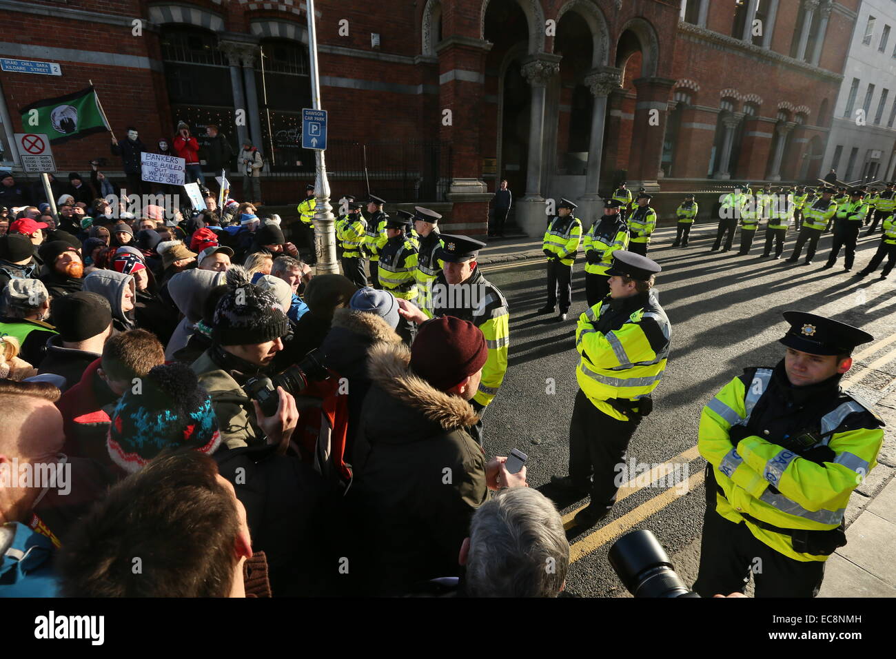 Dublino, Irlanda. 10 dicembre, 2014. Garda ufficiali a stare di fronte di manifestanti a un blocco stradale in Kildare Street. Immagine da un grande anti-tariffe idriche protesta nel centro della città di Dublino. Migliaia di persone partecipano alla destra2acqua marzo attraverso la capitale irlandese. Credito: Brendan Donnelly/Alamy Live News Foto Stock