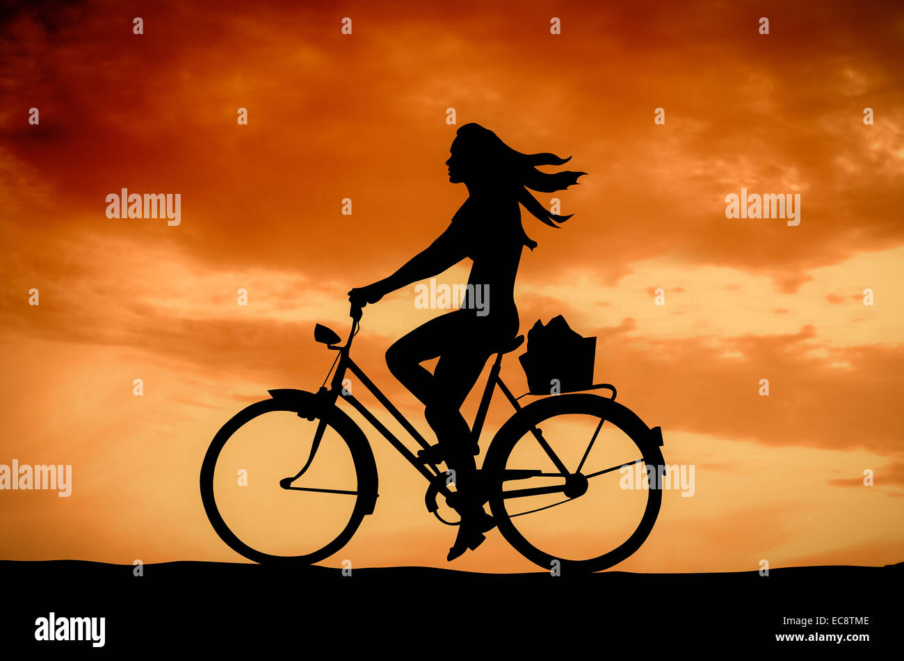 Una ragazza su una bici al tramonto Foto Stock