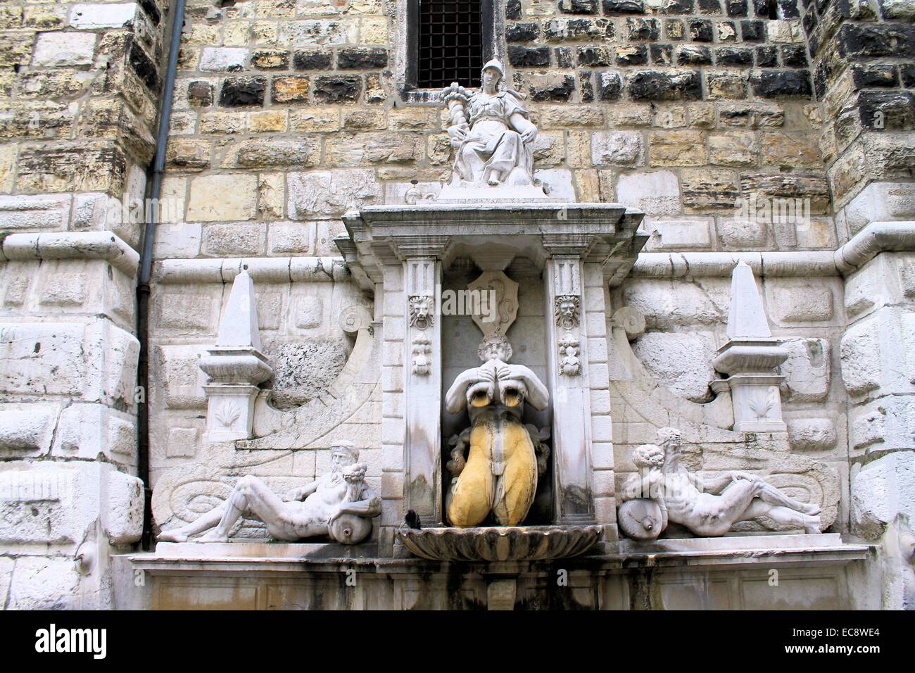 Statua di marmo ai piedi di una storica torre a Brescia in Italia Foto Stock
