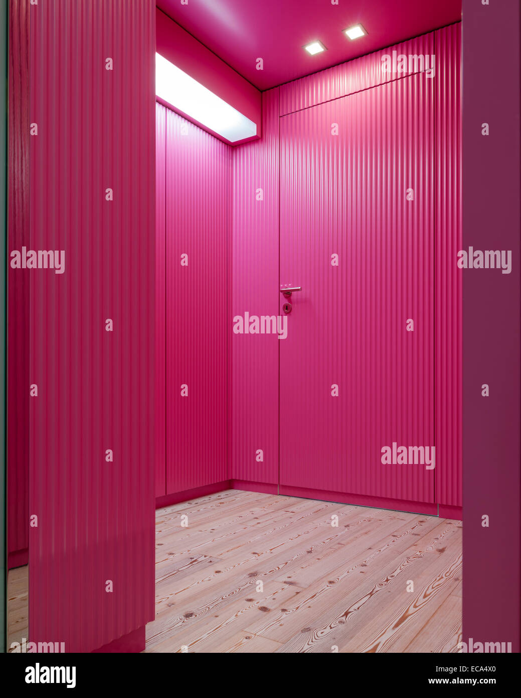 Ondulati, rosa pannellatura in legno nel corridoio con pavimenti in pino Foto Stock