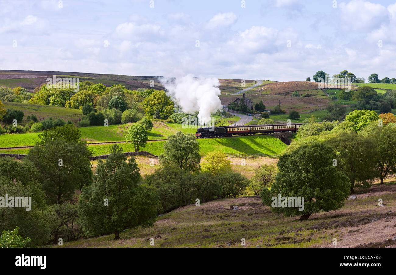 Vintage treno a vapore che fa il suo modo di Pickering attraverso il North York Moors vicino a Goathland, nello Yorkshire, Regno Unito. Foto Stock