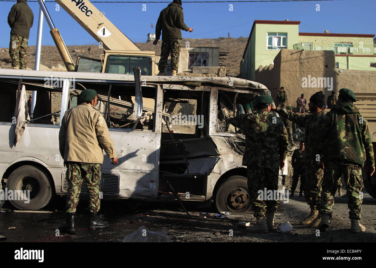 A Kabul, Afghanistan. Undicesimo Dec, 2014. Le forze di sicurezza afgane trasferire un distrutto il bus che è indirizzata da un attentato suicida a Kabul, Afghanistan, Dic 11, 2014. 'Un attentatore suicida si è fatto esplodere accanto ad un bus dell esercito nazionale di personale presso 07:15 ora locale in Tangi Tarakhil area nella periferia della capitale Kabul, uccidendo sei personale dell'esercito e il ferimento di altri undici,' una dichiarazione del ministero della Difesa ha detto. Credito: Rahmin/Xinhua/Alamy Live News Foto Stock