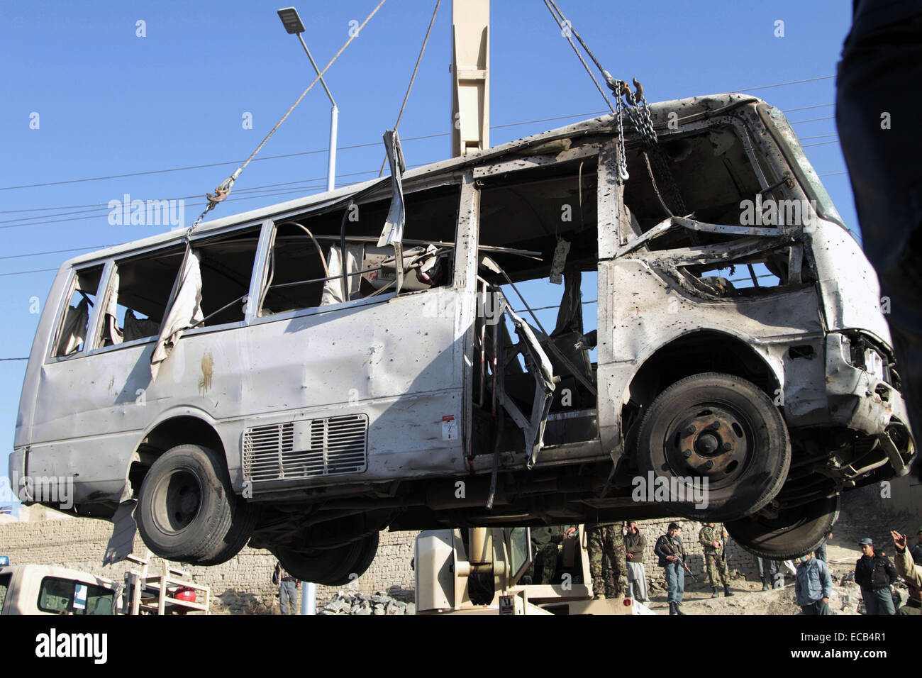 A Kabul, Afghanistan. Undicesimo Dec, 2014. Le forze di sicurezza afgane trasferire un distrutto il bus che è indirizzata da un attentato suicida a Kabul, Afghanistan, Dic 11, 2014. 'Un attentatore suicida si è fatto esplodere accanto ad un bus dell esercito nazionale di personale presso 07:15 ora locale in Tangi Tarakhil area nella periferia della capitale Kabul, uccidendo sei personale dell'esercito e il ferimento di altri undici,' una dichiarazione del ministero della Difesa ha detto. Credito: Rahmin/Xinhua/Alamy Live News Foto Stock
