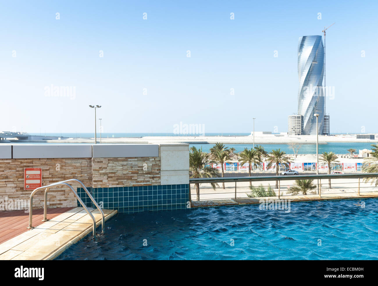 Manama, Bahrain - 21 Novembre 2014: piscina e Regno Tower in costruzione all'orizzonte a Manama, la capitale dei Foto Stock