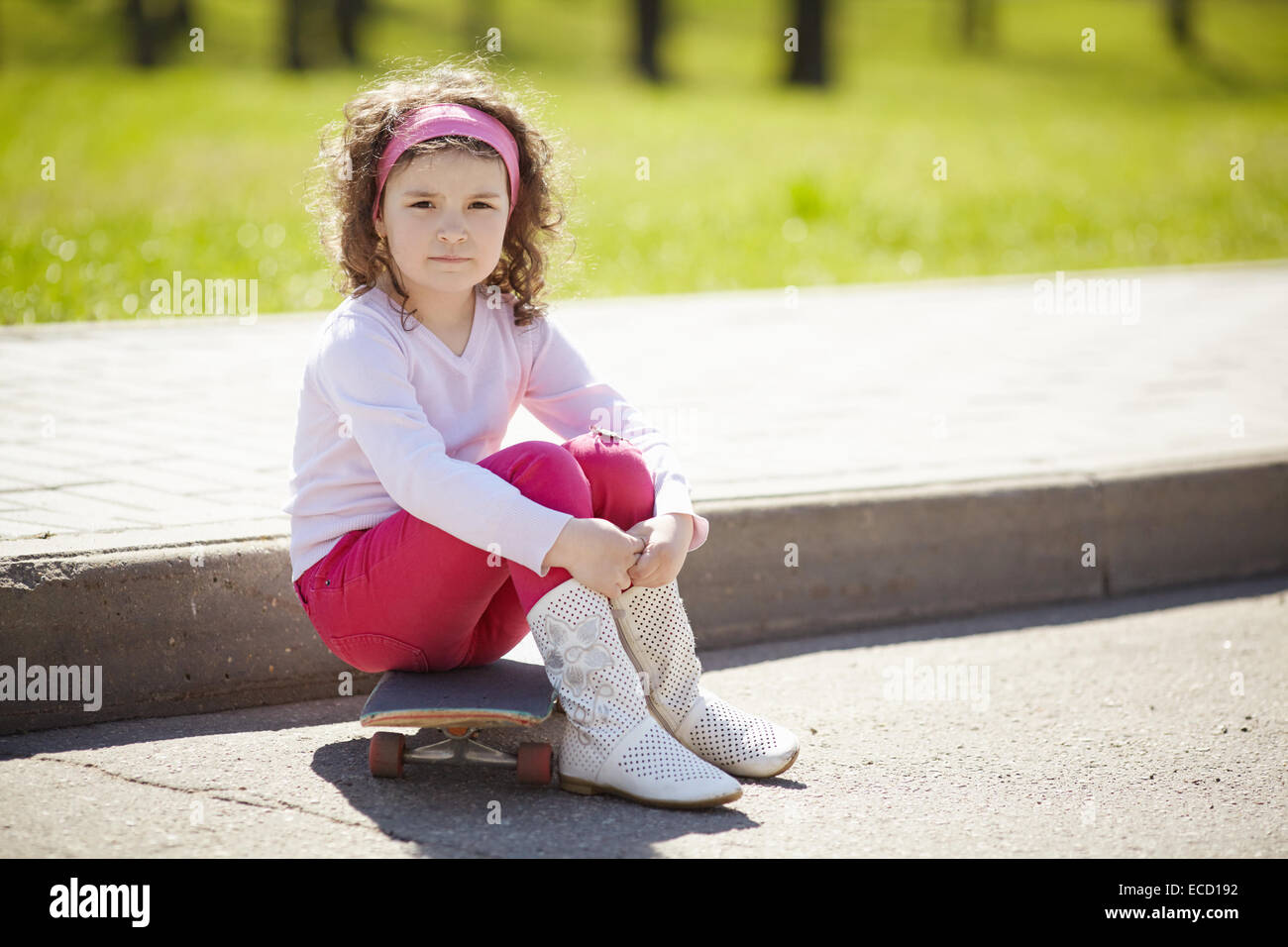 Bambina con lo skateboard per la passeggiata Foto Stock